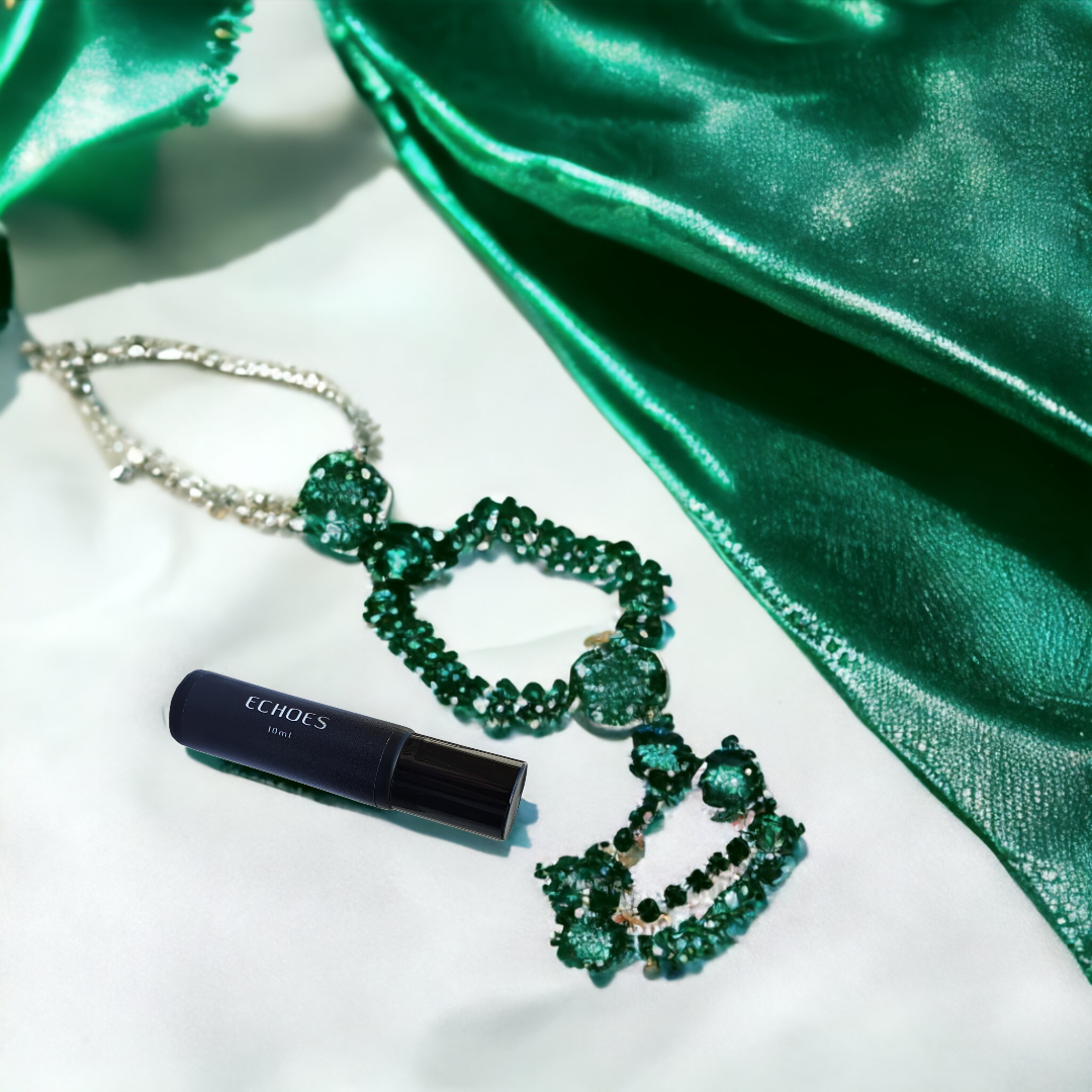 Bottle of Echoes of Dubai Emerald next to emerald jewellery